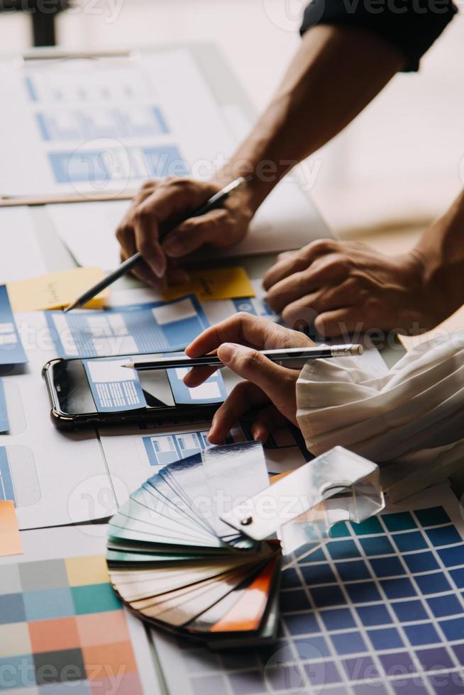 Close up ux developer and ui designer use augmented reality brainstorming about mobile app interface wireframe design on desk at modern office.Creative digital development agency photo