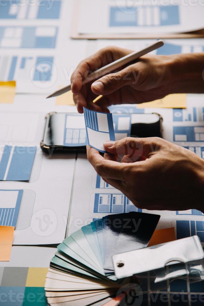 Close up ux developer and ui designer use augmented reality brainstorming about mobile app interface wireframe design on desk at modern office.Creative digital development agency photo