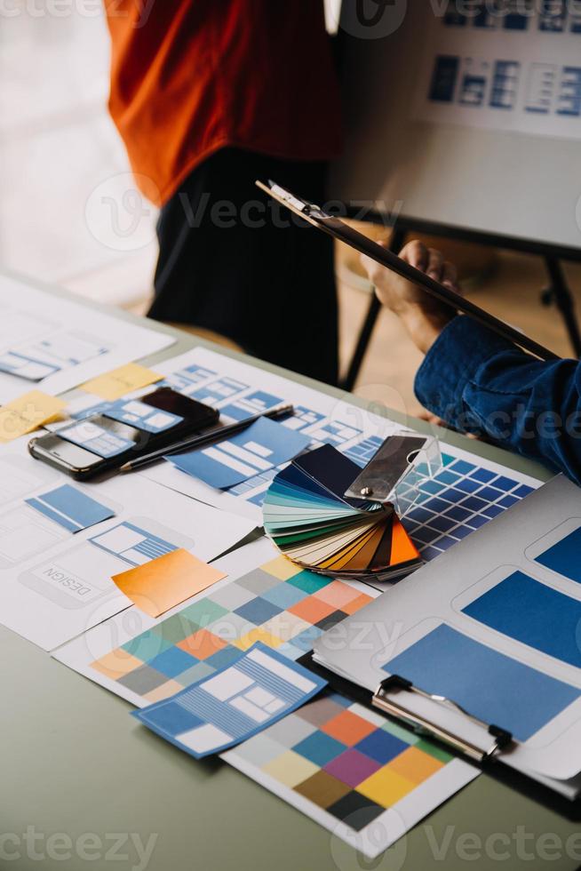 Close up ux developer and ui designer use augmented reality brainstorming about mobile app interface wireframe design on desk at modern office.Creative digital development agency photo