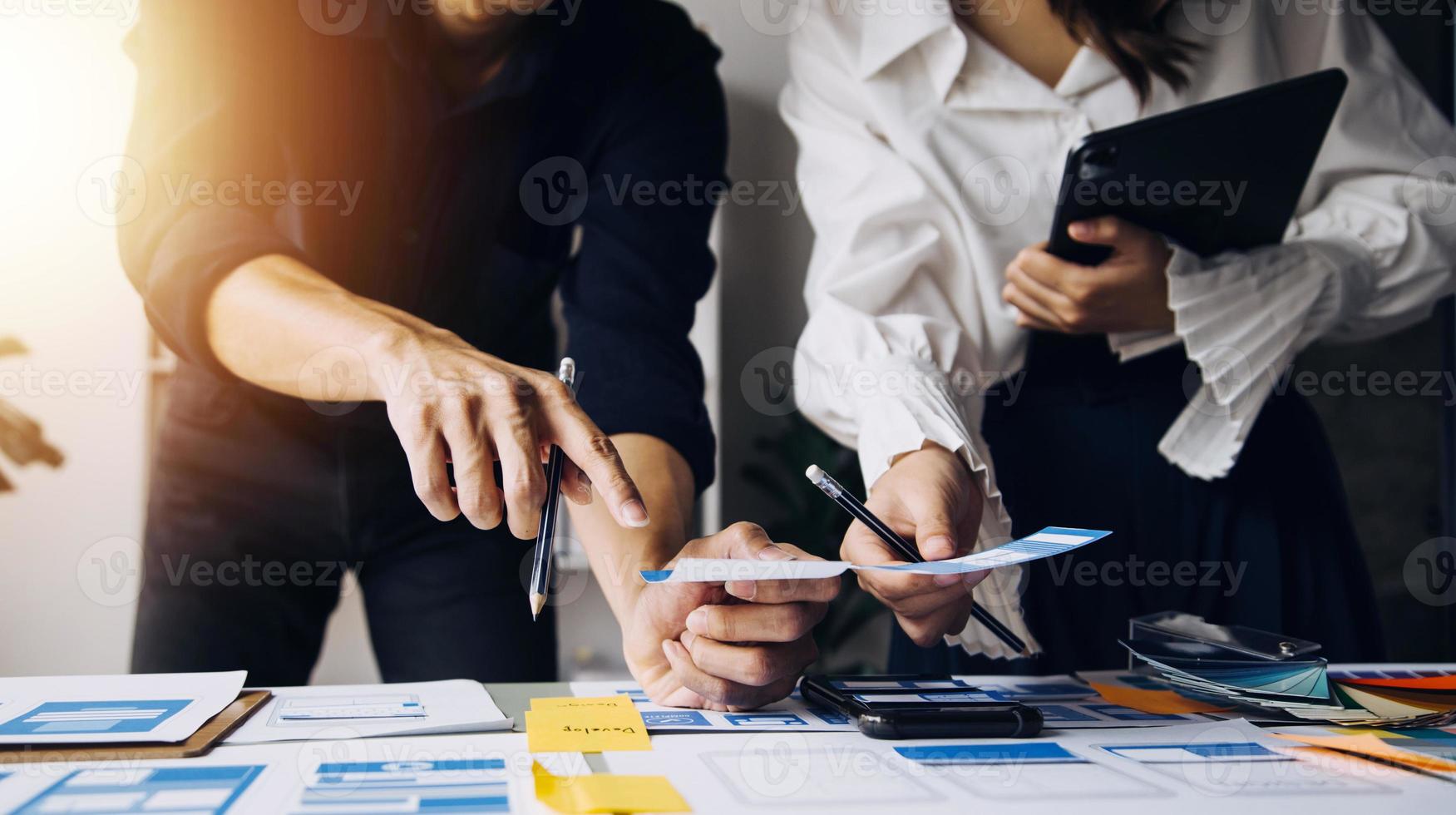 Close up ux developer and ui designer use augmented reality brainstorming about mobile app interface wireframe design on desk at modern office.Creative digital development agency photo