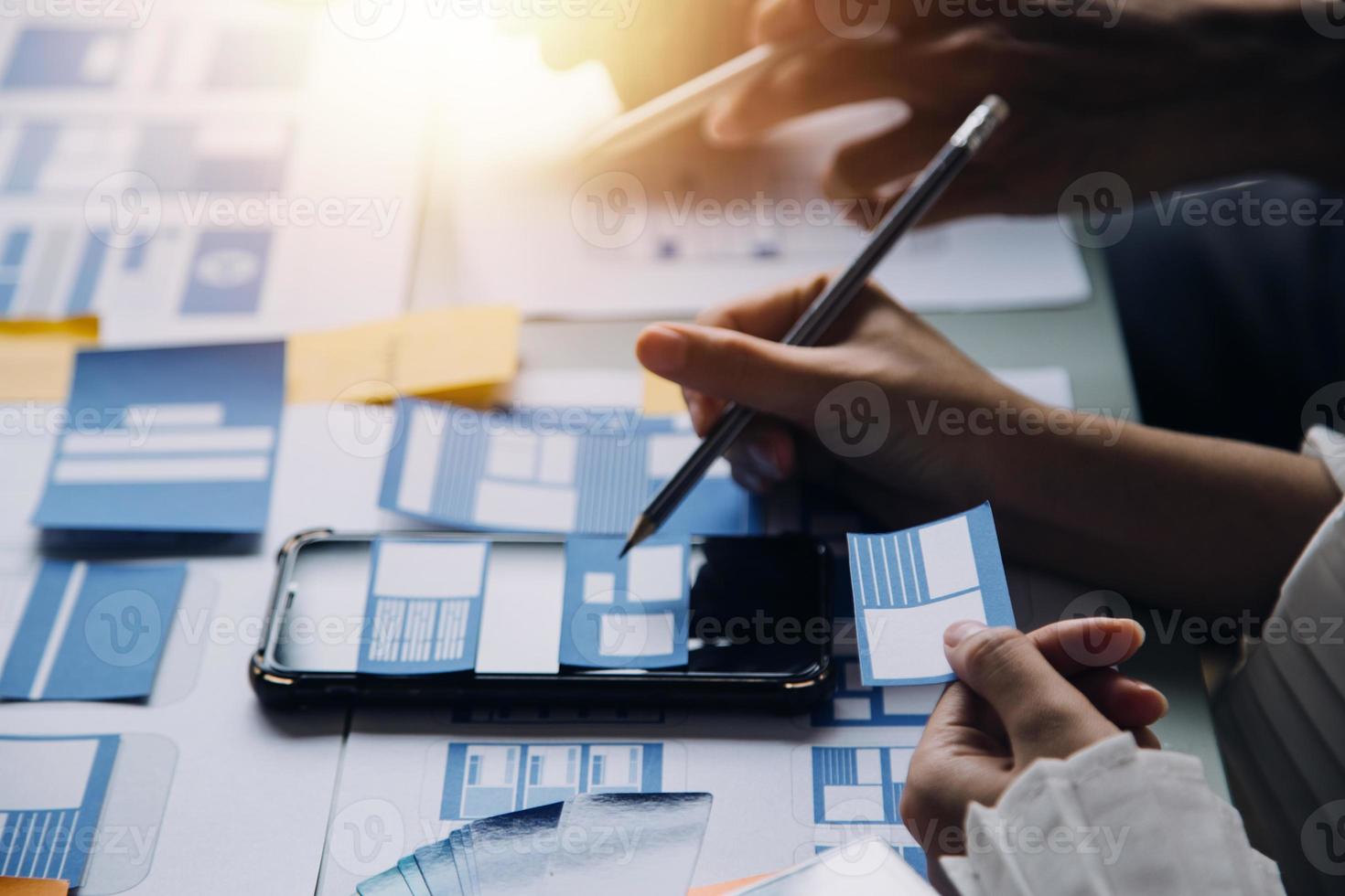 Close up ux developer and ui designer use augmented reality brainstorming about mobile app interface wireframe design on desk at modern office.Creative digital development agency photo