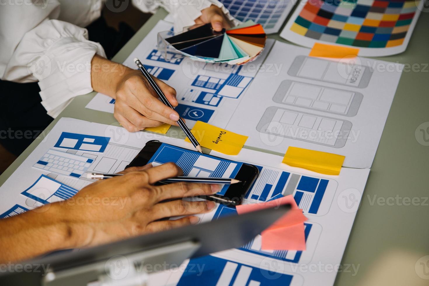 Close up ux developer and ui designer use augmented reality brainstorming about mobile app interface wireframe design on desk at modern office.Creative digital development agency photo