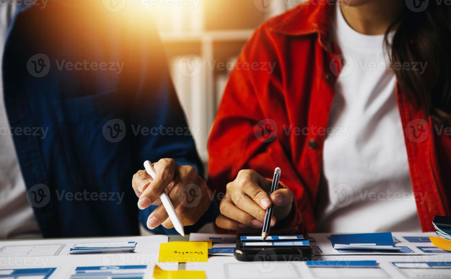 Close up ux developer and ui designer use augmented reality brainstorming about mobile app interface wireframe design on desk at modern office.Creative digital development agency photo