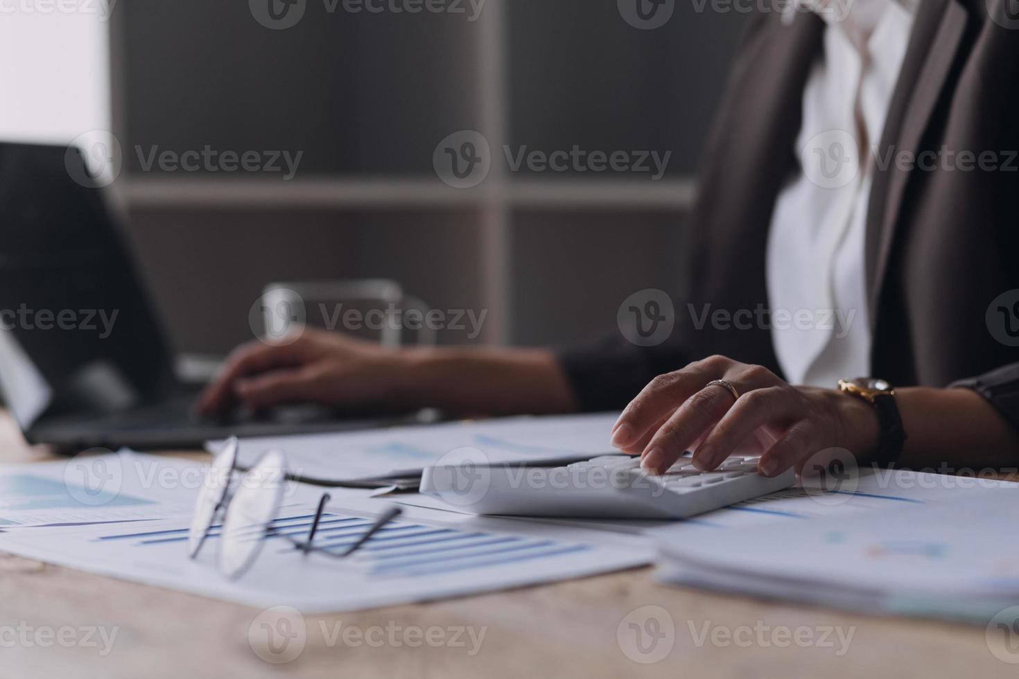 Businesswoman or accountant working Financial investment on calculator, calculate, analyze business and marketing growth on financial document data graph, Accounting, Economic, commercial concept. photo