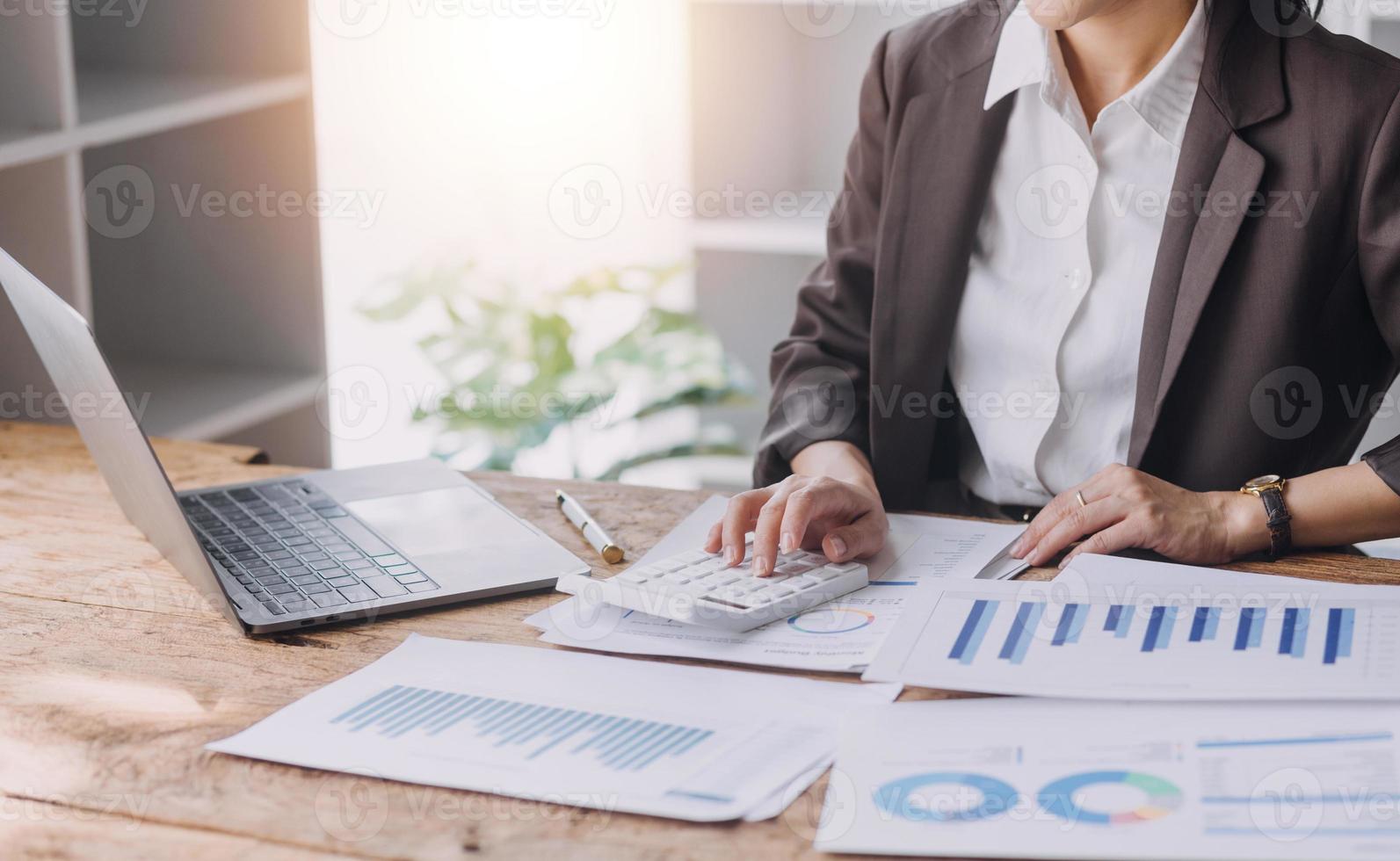 Businesswoman or accountant working Financial investment on calculator, calculate, analyze business and marketing growth on financial document data graph, Accounting, Economic, commercial concept. photo