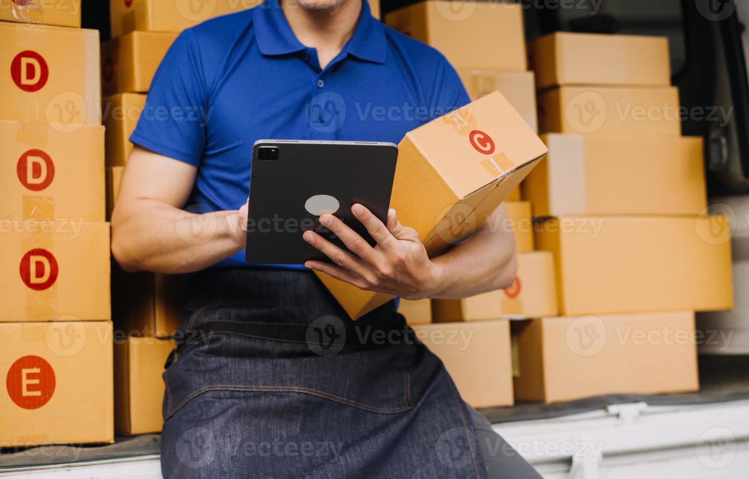 Asian business men use laptop computer checking customer order online shipping boxes at home. Starting Small business entrepreneur SME freelance photo