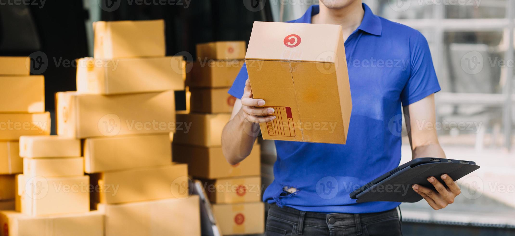 SME entrepreneur Small business entrepreneurs Online selling ideas,Happy Young Asian business owner work on computer and a boxs at home,delivery SME procurement package box deliver to customers, photo