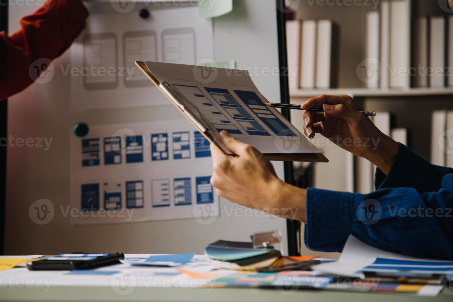 Close up ux developer and ui designer use augmented reality brainstorming about mobile app interface wireframe design on desk at modern office.Creative digital development agency photo