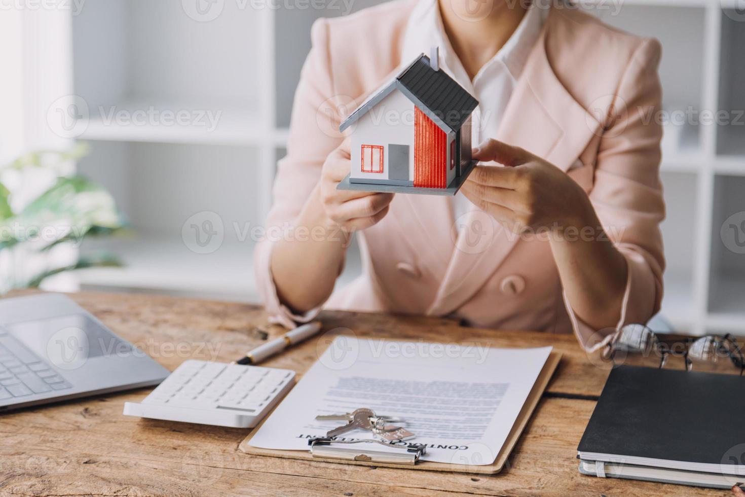 Real estate broker agent presenting and consult to customer to decision making sign insurance form agreement, buy and sell home model, concerning mortgage loan offer for and house insurance photo