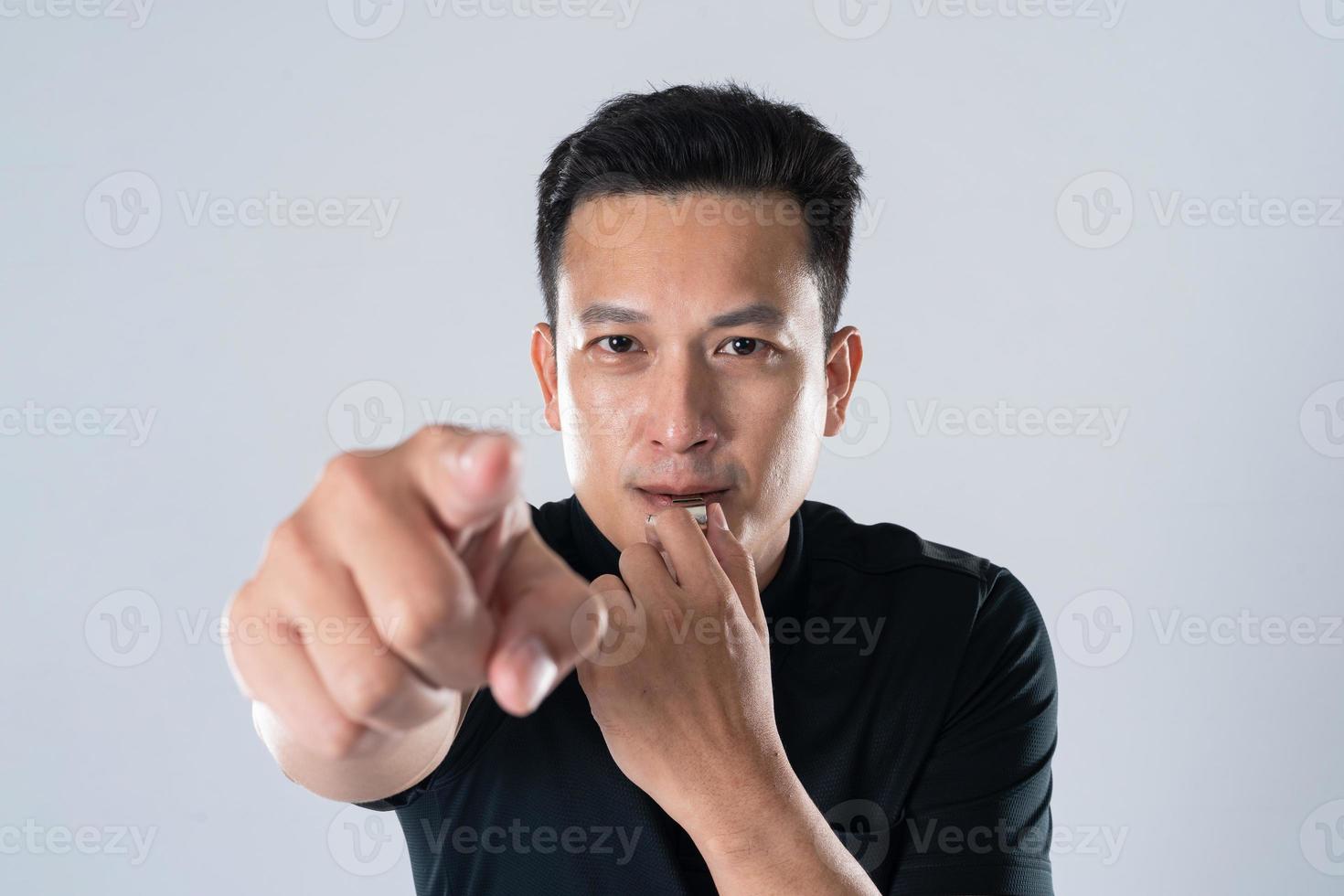 Football referee holding whistle and pointing with isolated hand. photo