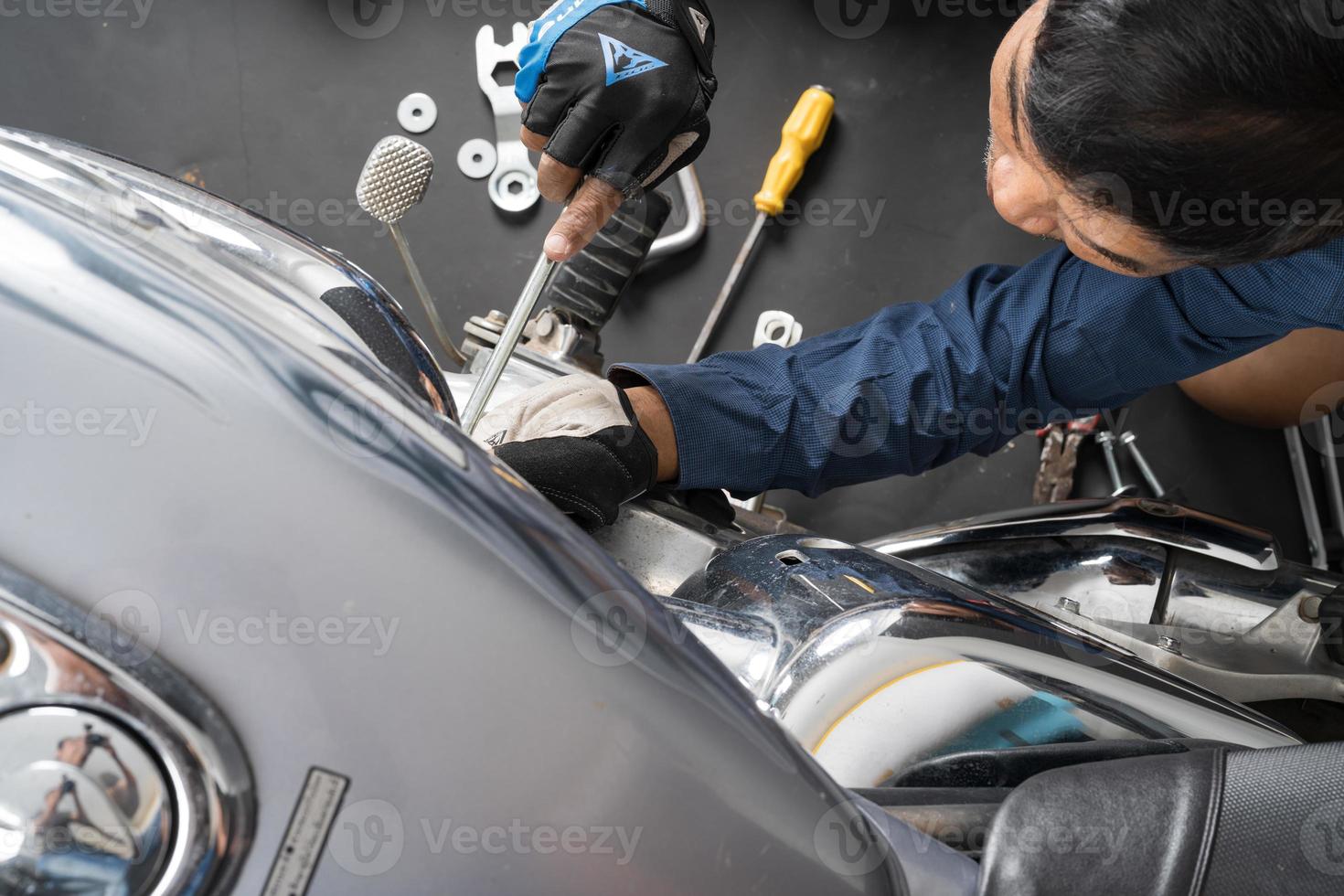 People are repairing a motorcycle Use a wrench and a screwdriver to work photo