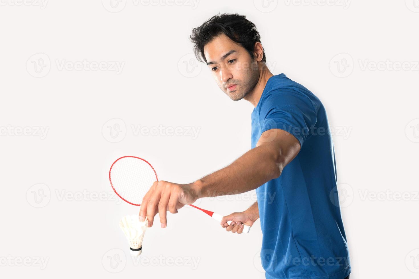 A badminton player in sportswear stands holding a racket and shuttlecock. photo