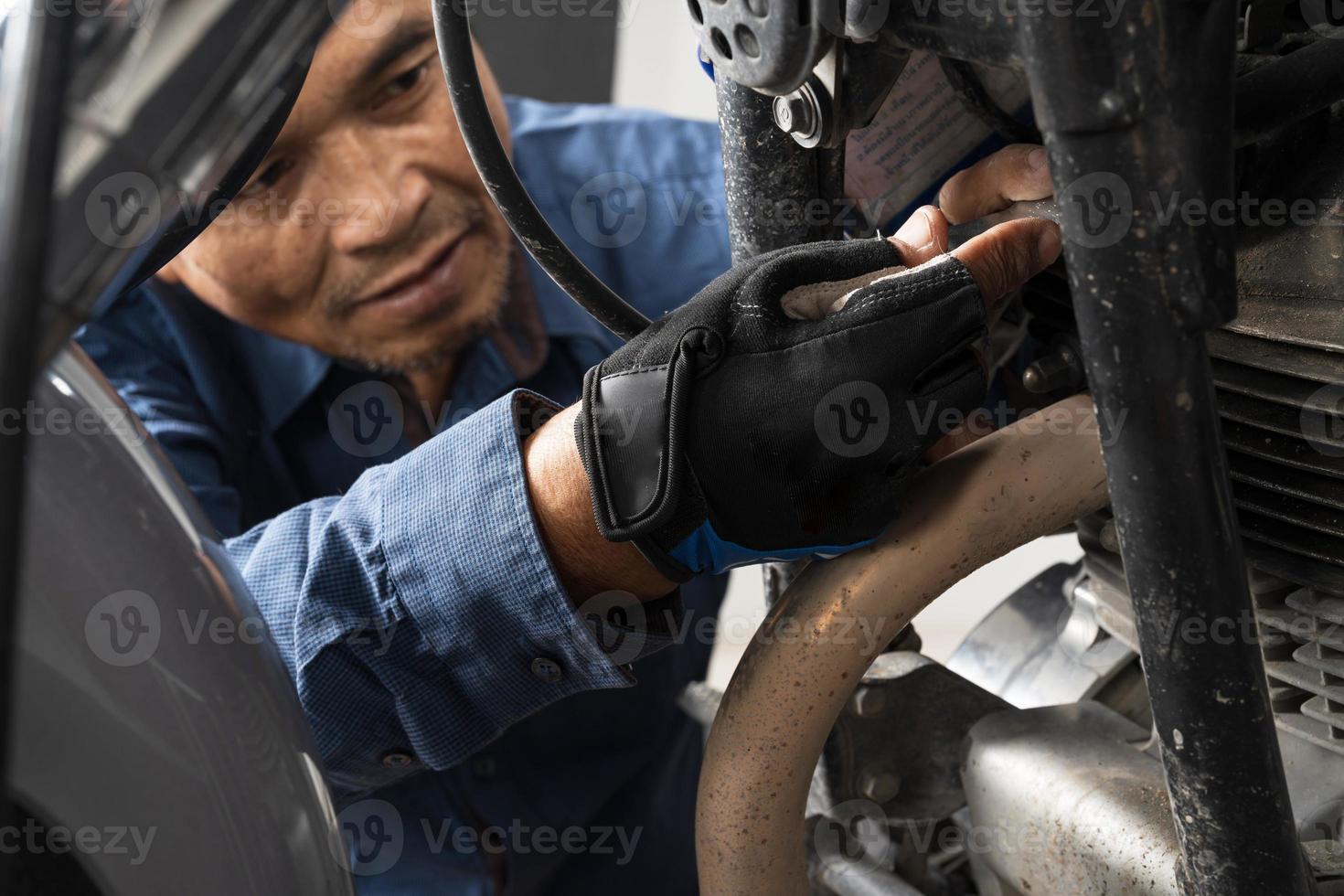People are repairing a motorcycle Use a wrench and a screwdriver to work photo