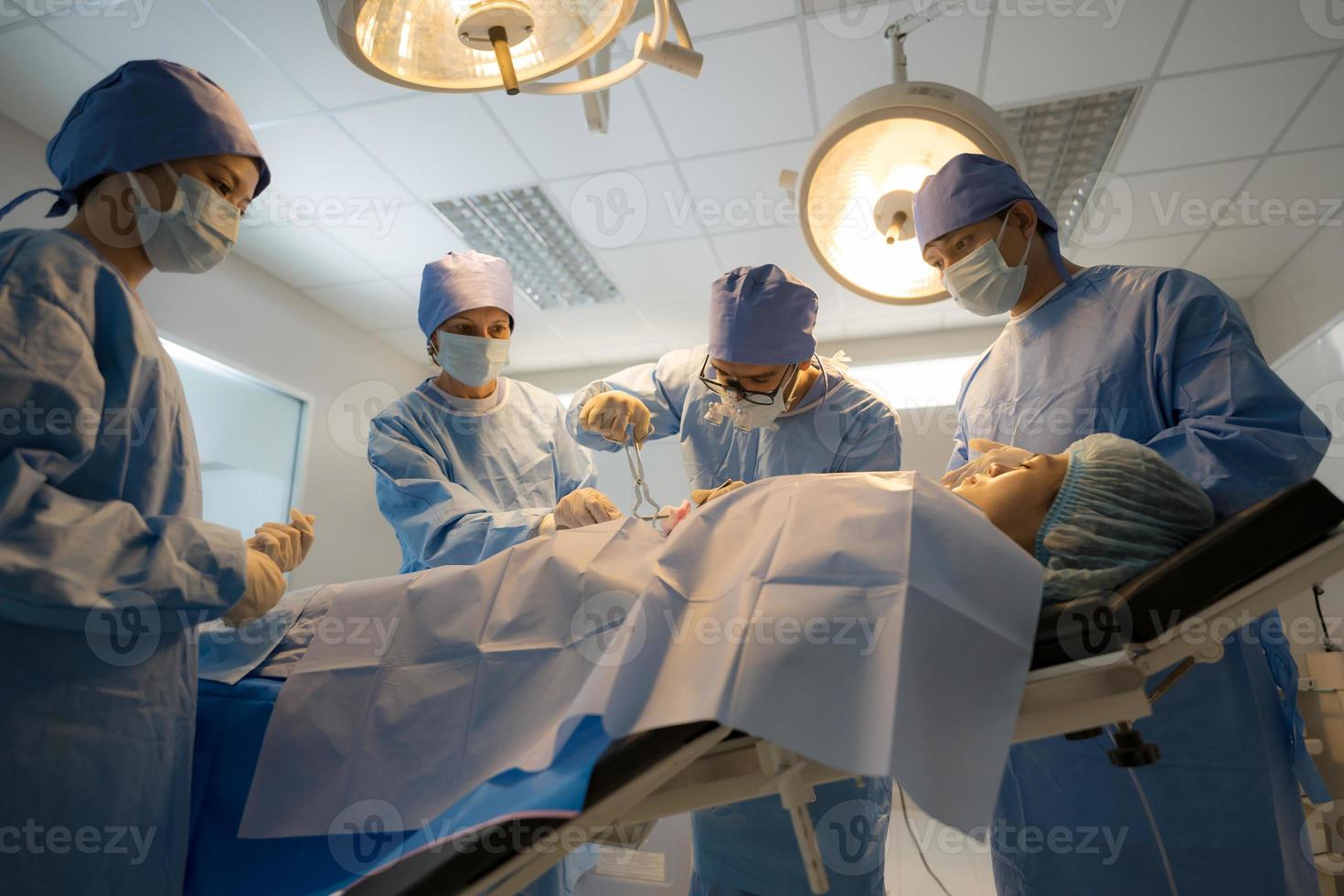 doctor, enfermero haciendo cirugía en paciente. foto