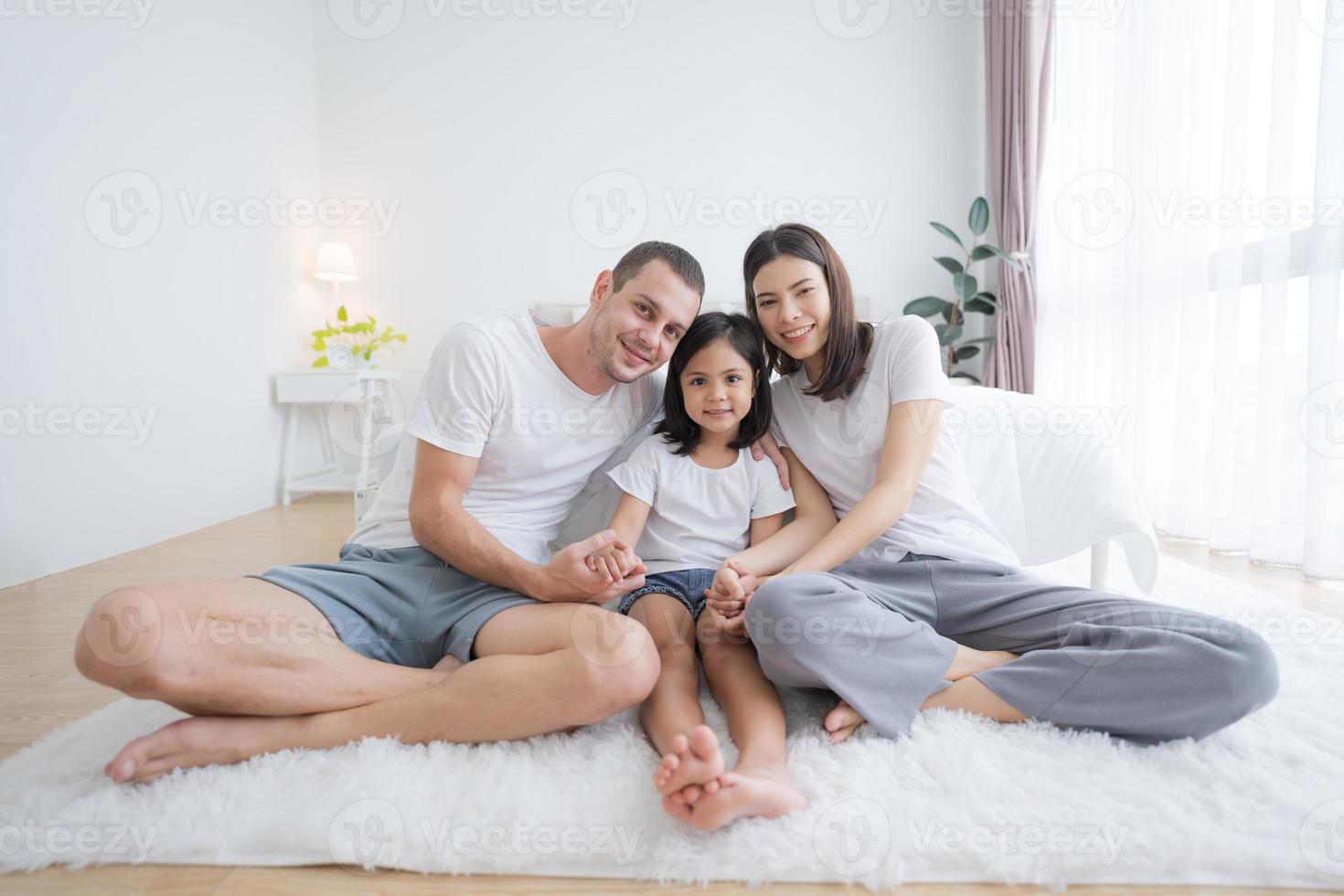 Happy family sitting on the floor with their baby. photo