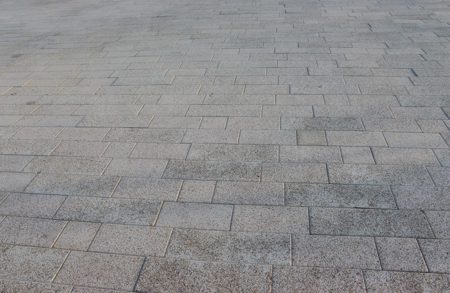 Granite cobblestoned pavement background with regular design and crosses,dark photo