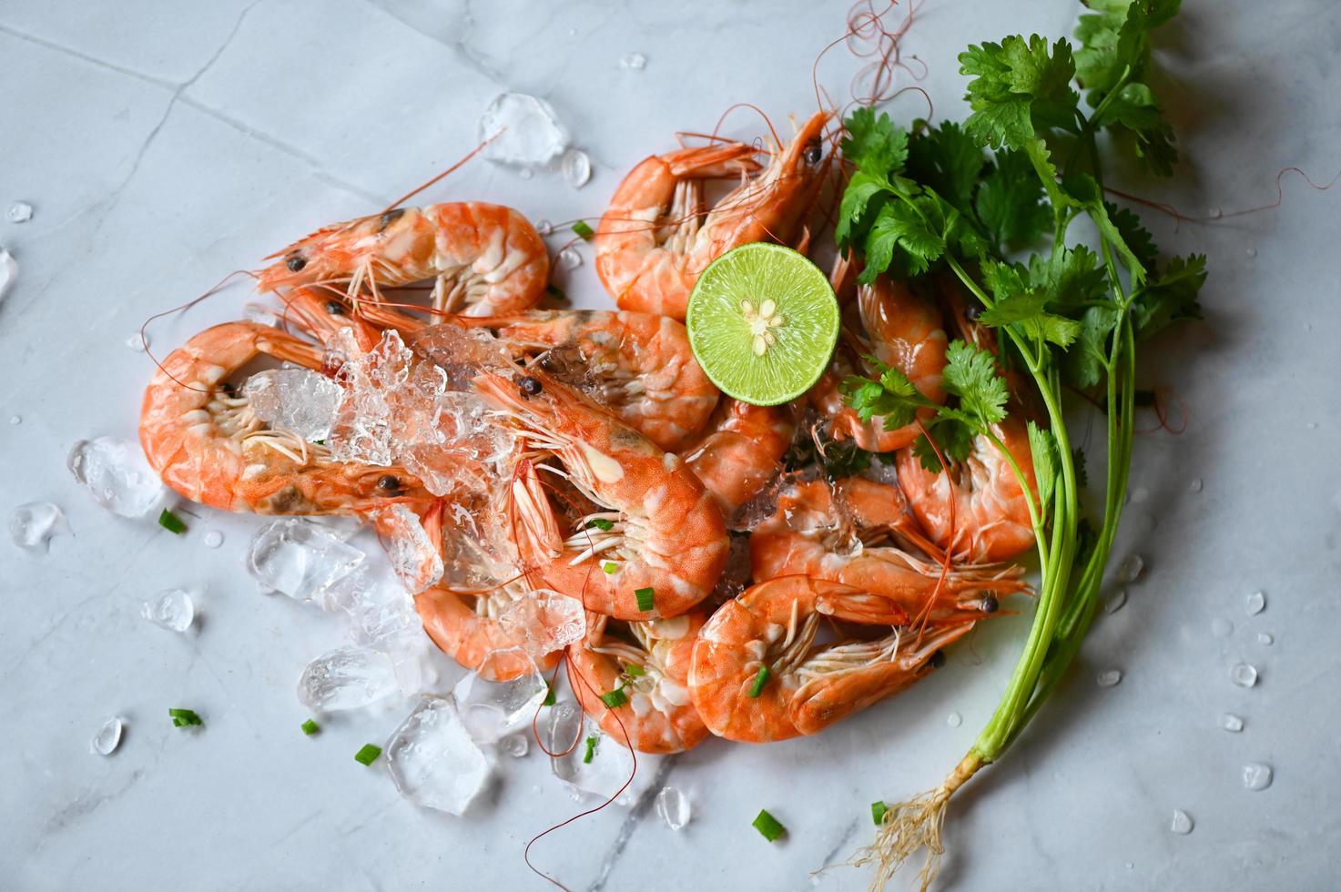 Cocinando camarón comida en blanco plato antecedentes comida mesa alimento, Fresco camarones langostinos Mariscos limón Lima con hierbas y especia foto