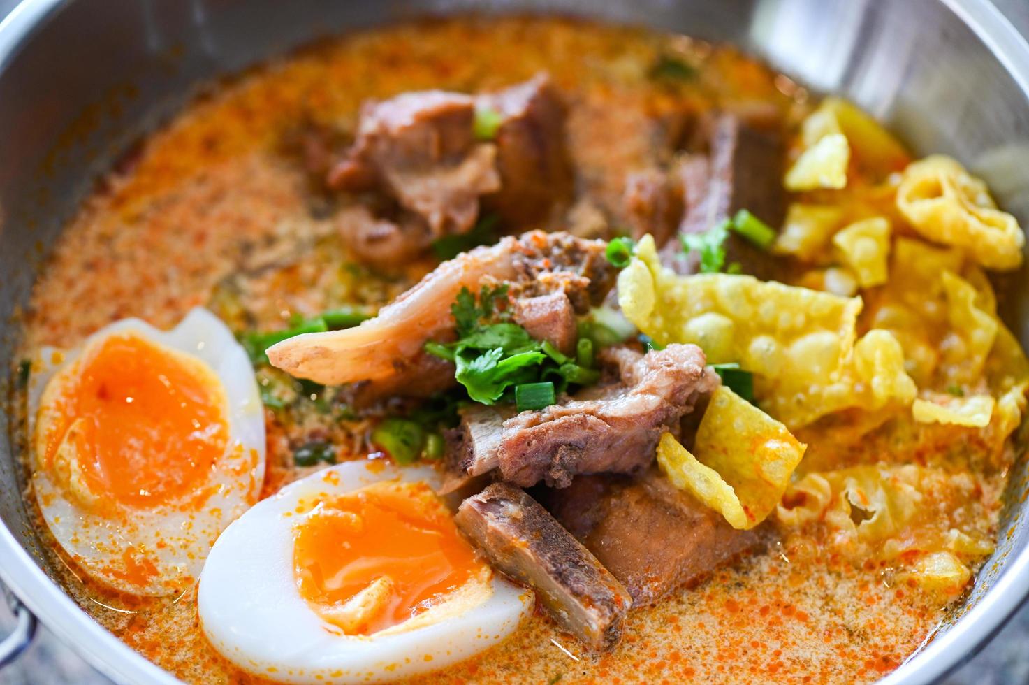 curry bone soup - bone soup pork with boiled eggs in hot pot, Thai food tom yum hot and sour soup photo