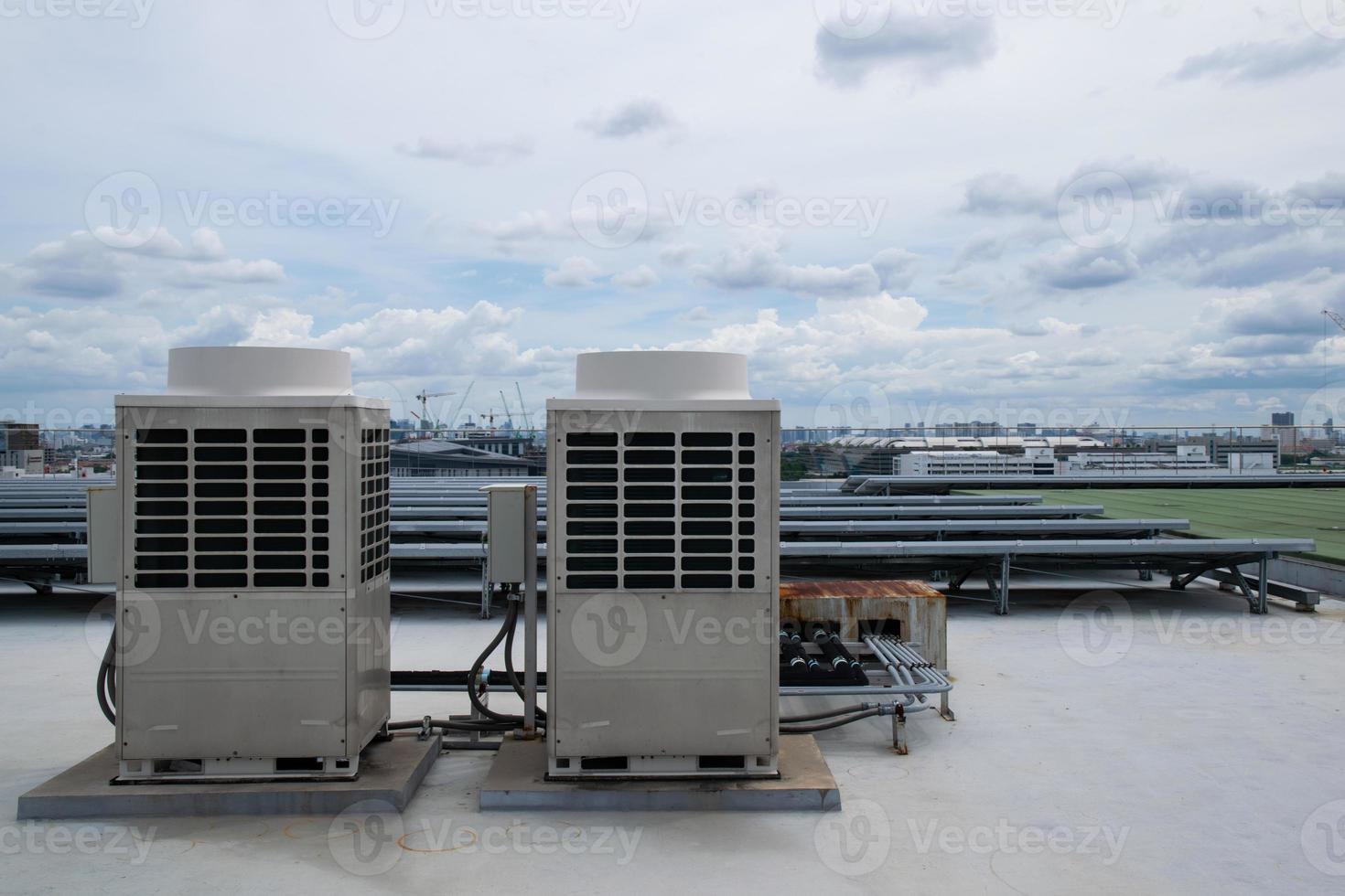 Air conditioner units HVAC on a roof of industrial building with blue sky. photo