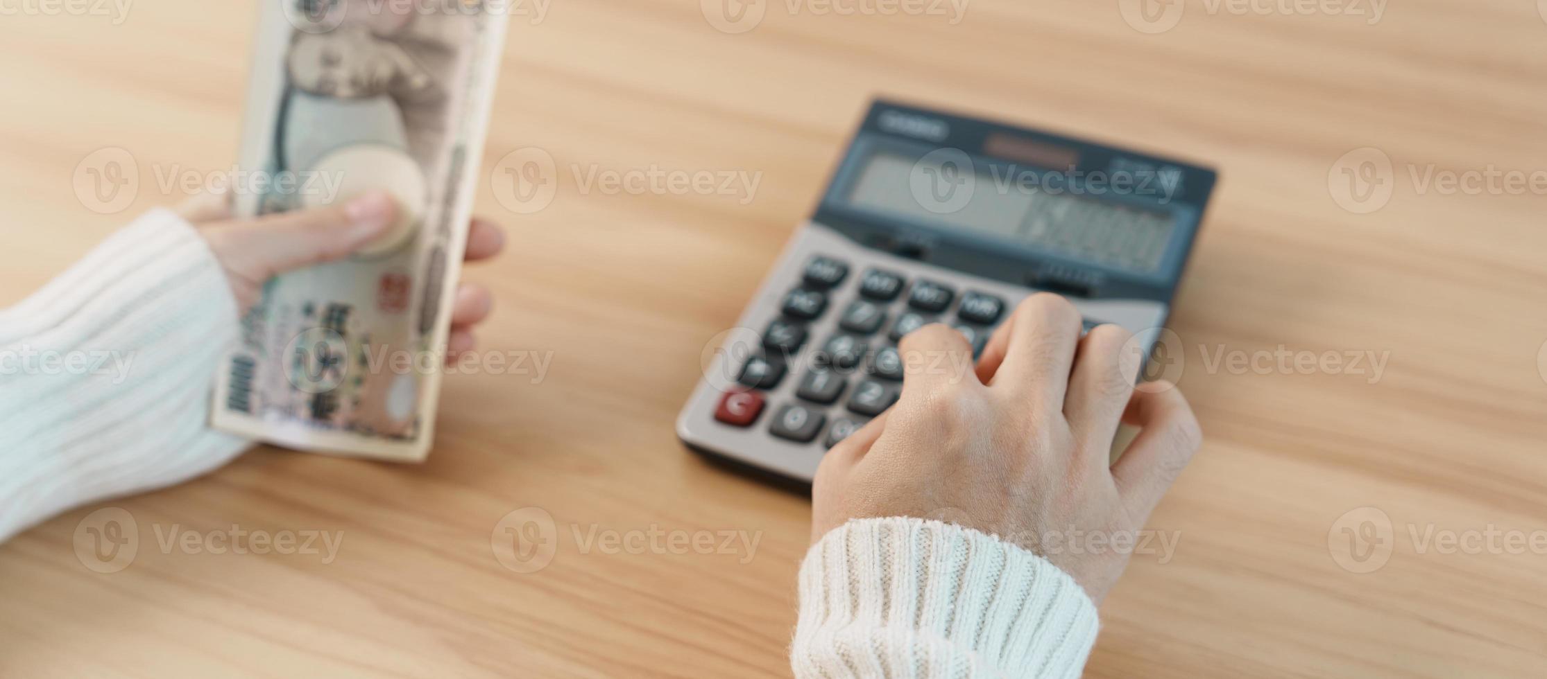 mano de mujer contando billetes de yen japonés con calculadora. dinero de mil yenes. Japón efectivo, impuestos, economía de recesión, inflación, inversión, finanzas, ahorro, salarios y conceptos de pago foto