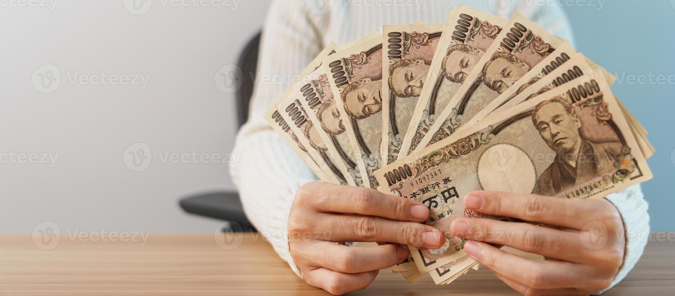 Woman hand counting Japanese Yen banknote over table background. Thousand Yen money. Japan cash, Tax, Recession Economy, Inflation, Investment, finance, savings, salary and payment concepts photo