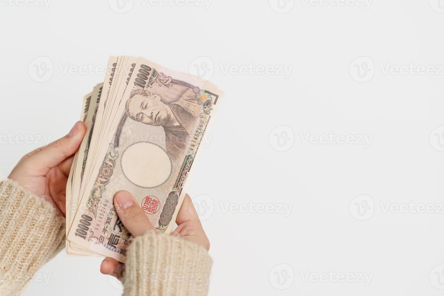 Woman hand holding Japanese Yen banknote stack. Thousand Yen money. Japan cash, Tax, Recession Economy, Inflation, Investment, finance and shopping payment concepts photo