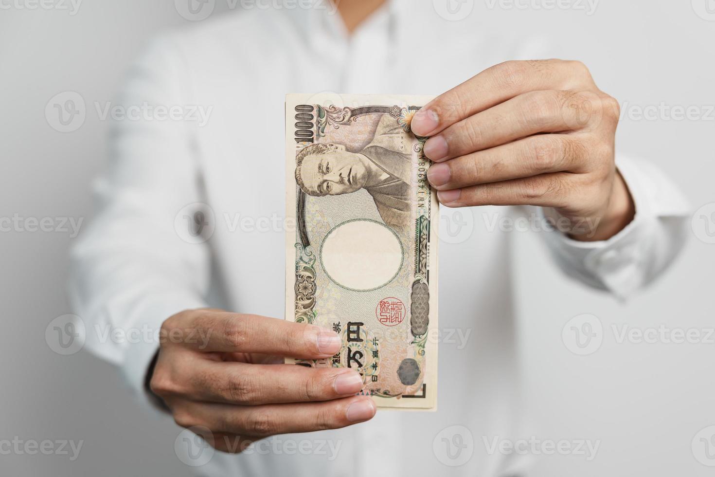 man hand holding Japanese Yen banknote stack. Thousand Yen money. Japan cash, Tax, Recession Economy, Inflation, Investment, finance and shopping payment concepts photo