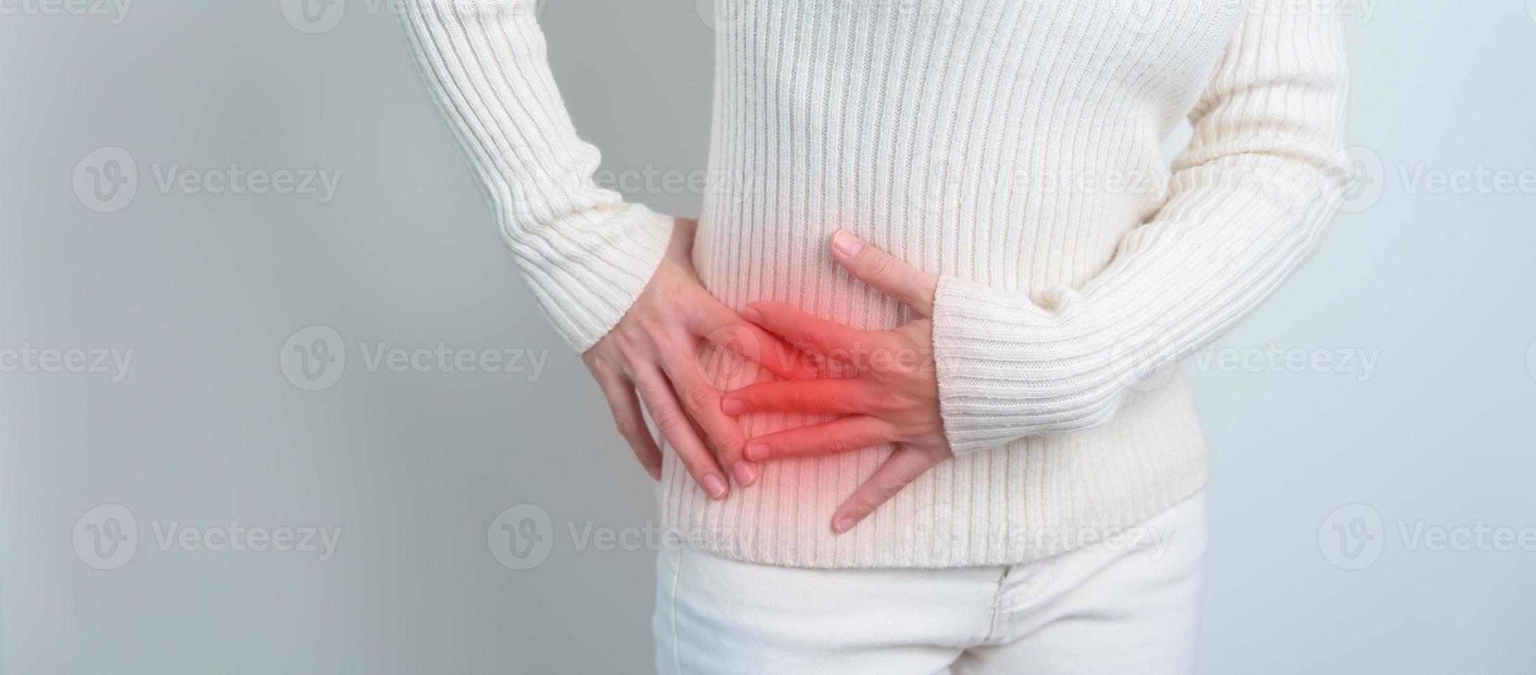 Young woman suffering from backache and flank pain on white background.  Cause of pain include UTI, kidney stones, gallbladder disease or muscle  problems. Health care and medical concept. Stock Photo