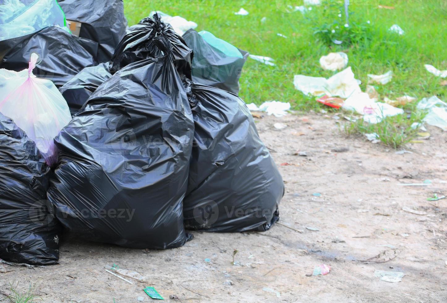 Pile black garbage bag roadside in the city photo