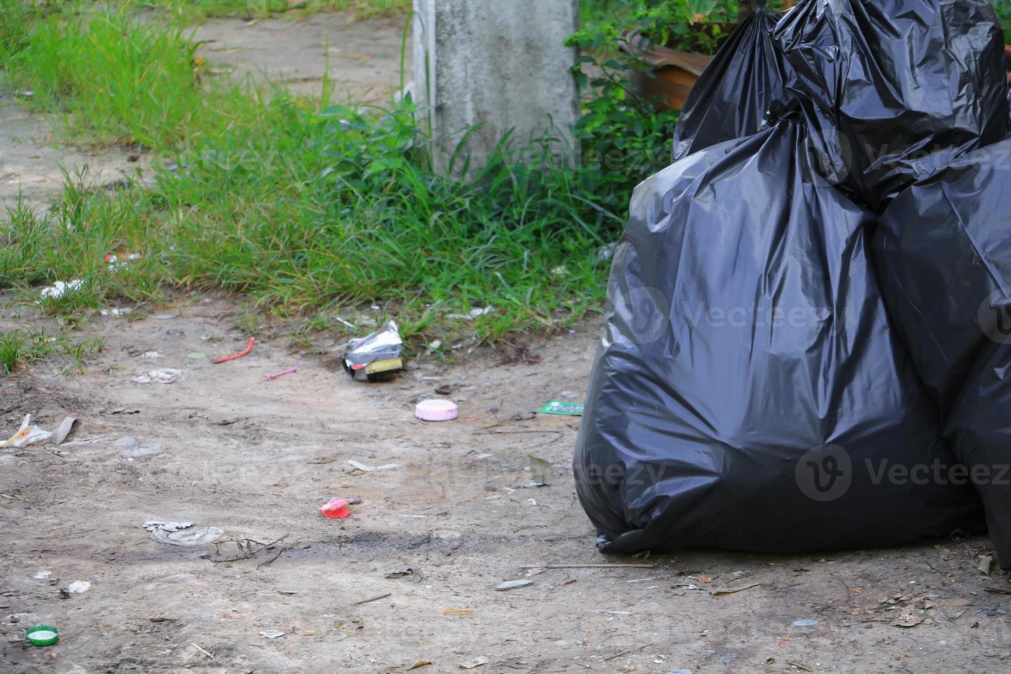 Pile black garbage bag roadside in the city photo