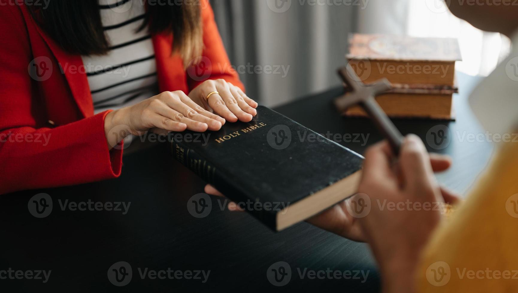 Woman's hand with cross .Concept of hope, faith, christianity, religion, church and pray to God. on the black table photo