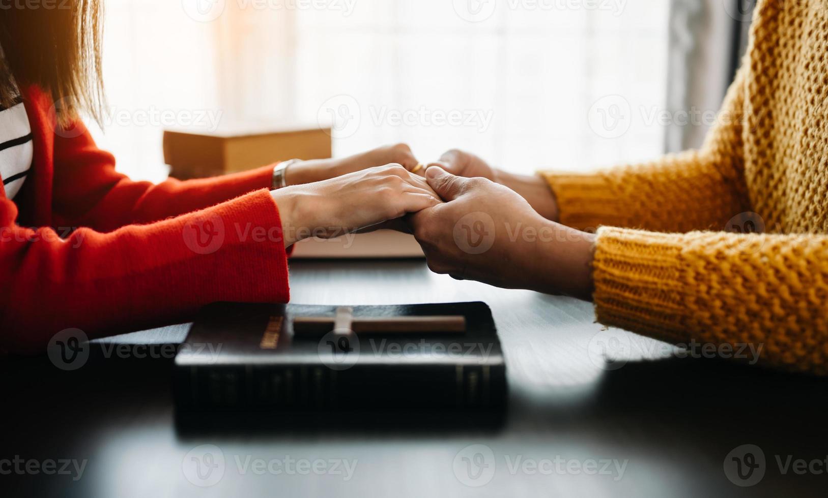 Woman's hand with cross .Concept of hope, faith, christianity, religion, church and pray to God. on the black table photo