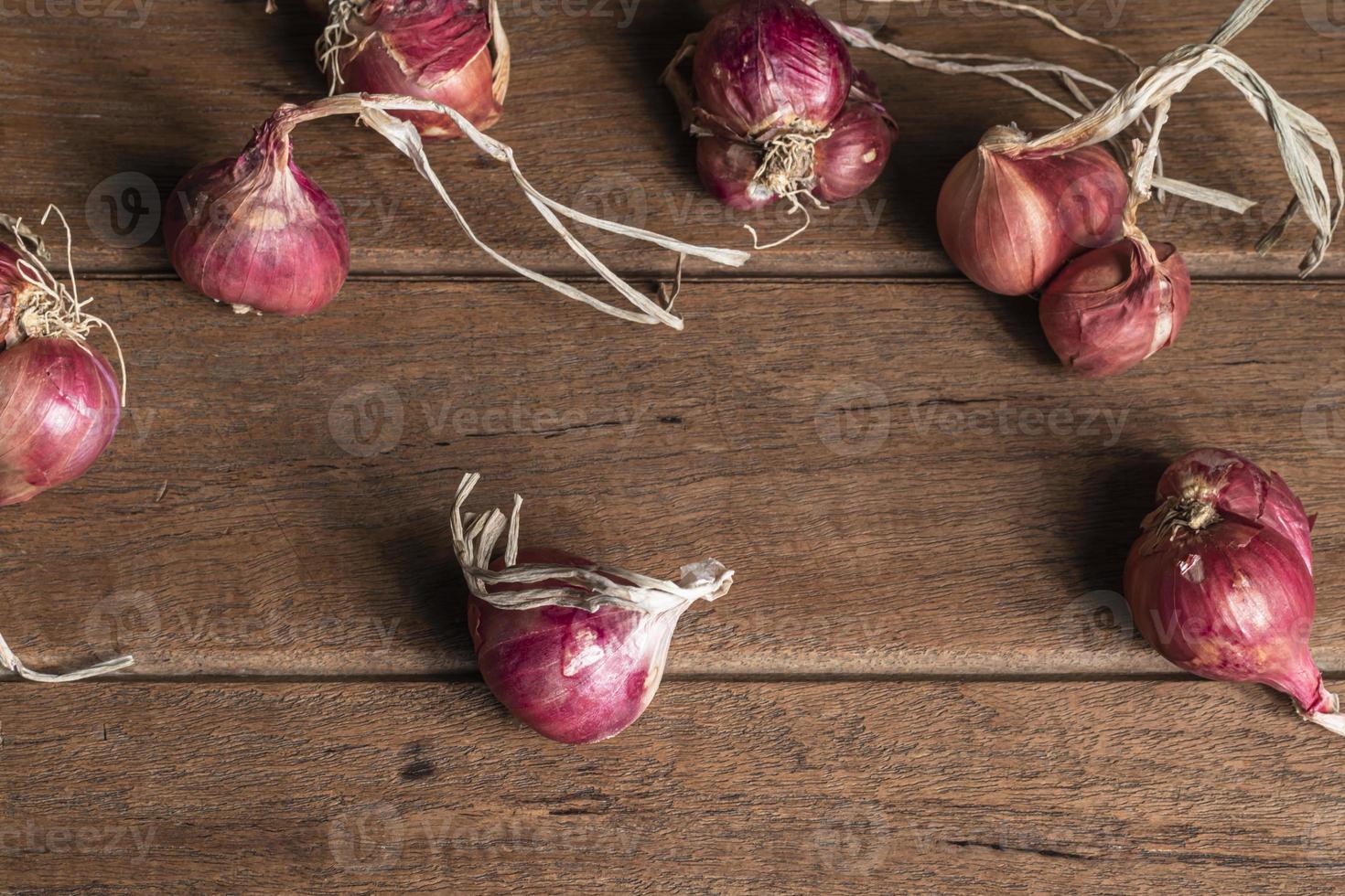 Shallot or red onion on wood table top view close up. photo