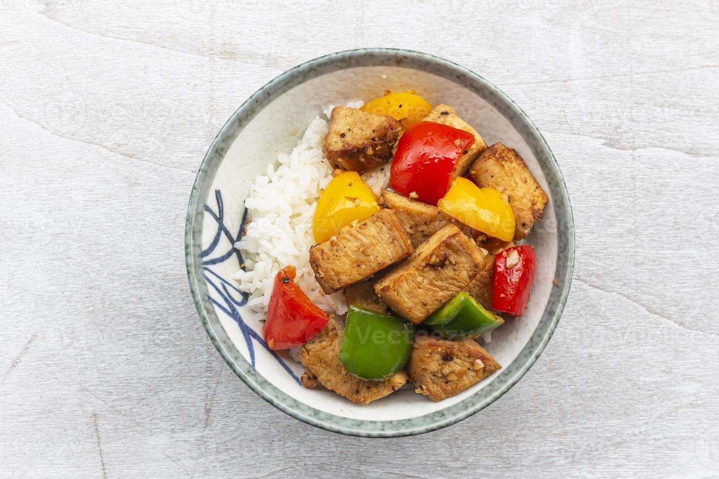 Food healthy stir fried chicken add sweet pepper has rice in bowl on wood table. photo