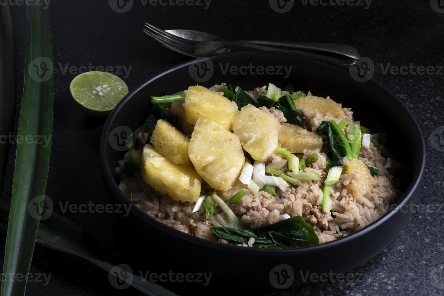 Pineapple fried rice has minced pork and vegetable in plate on stone table. photo