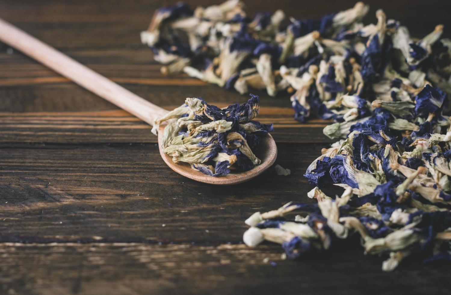 a dried butterfly pea flower on the spoon with wooden background photo
