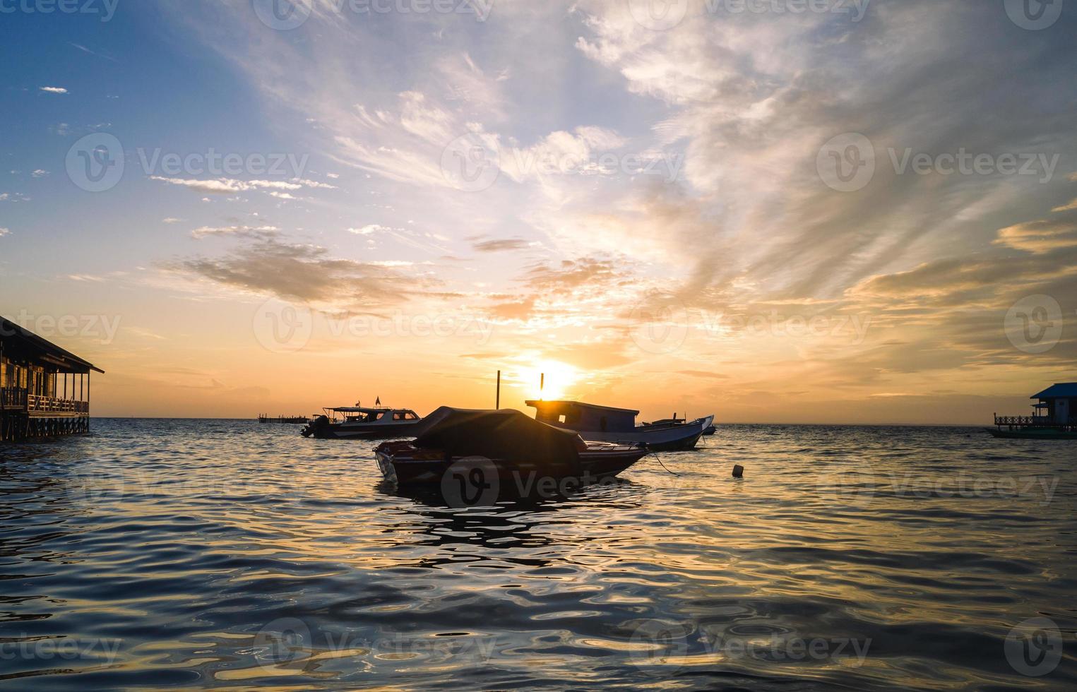 vistoso puesta de sol a el mar con vela barcos foto