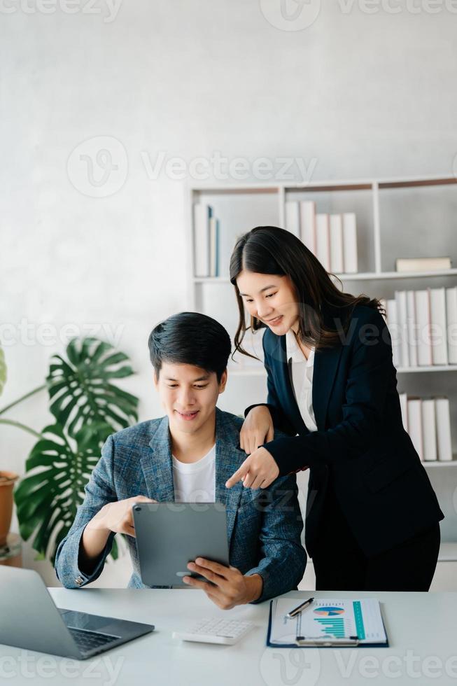 Businesswomen work and discuss their business plans. A Human employee explains and shows her colleague the results paper in modern office. photo