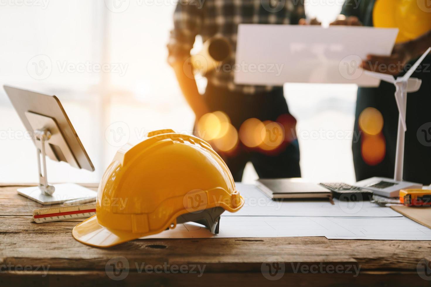Construction team shake hands greeting start new project plan behind yellow helmet on desk in office to consults about their building project.. photo