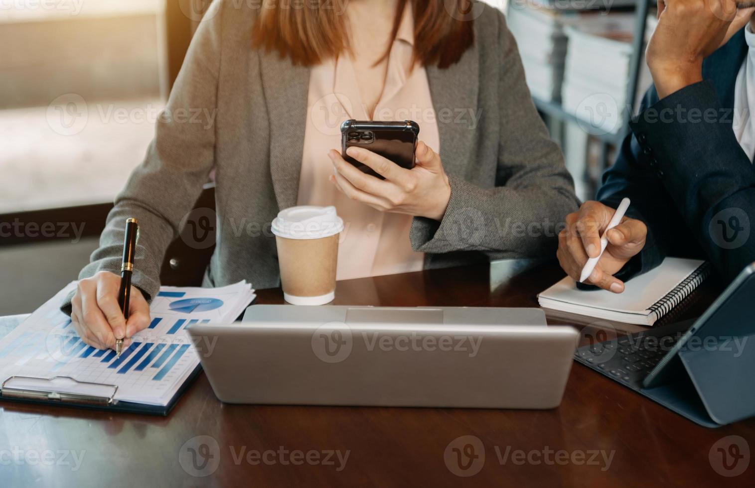 gente de negocios reunida en la oficina escribiendo notas sobre notas adhesivas portátiles, planificación de tabletas y estrategias de intercambio de ideas de colegas en la oficina foto