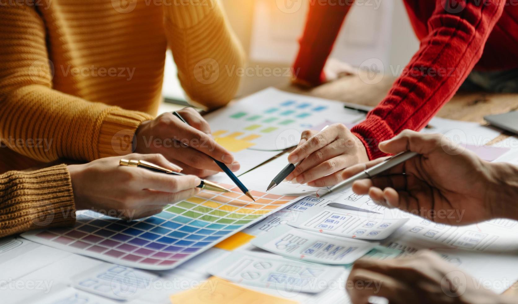 Close up view of UI developer team brainstorming on their project with laptop, smartphone and digital tablet. Creative digital development agency. photo