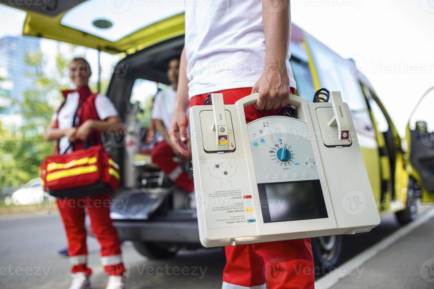 mano de el médico con desfibrilador equipos de el emergencia médico Servicio son respondiendo a un tráfico accidente. foto