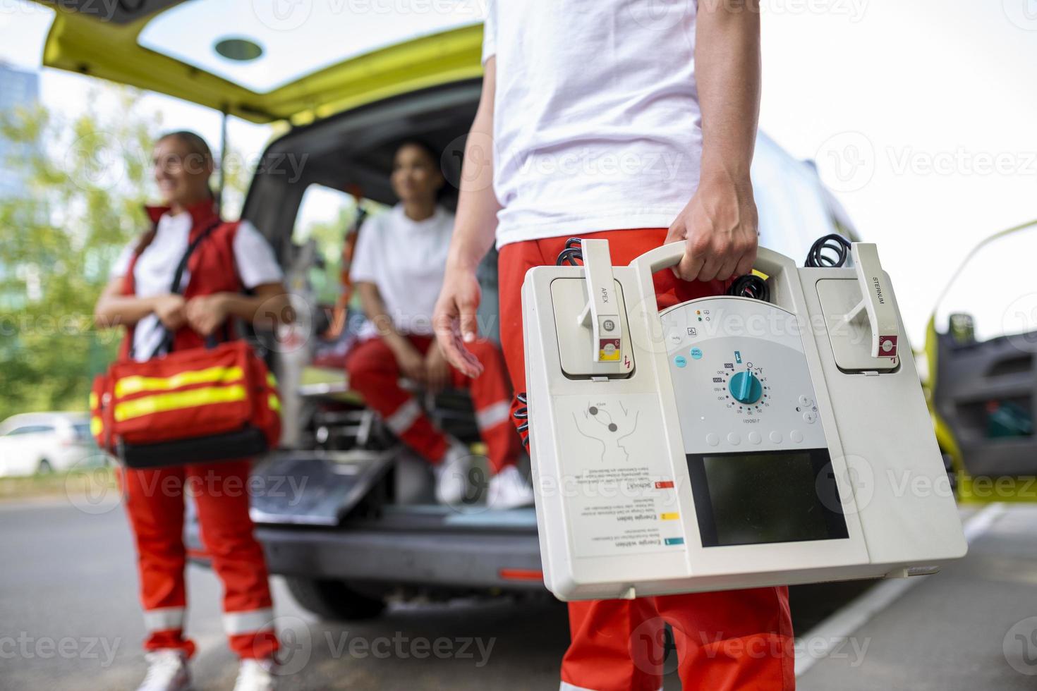 Hand of the doctor with defibrillator. Teams of the Emergency medical service are responding to an traffic accident. photo