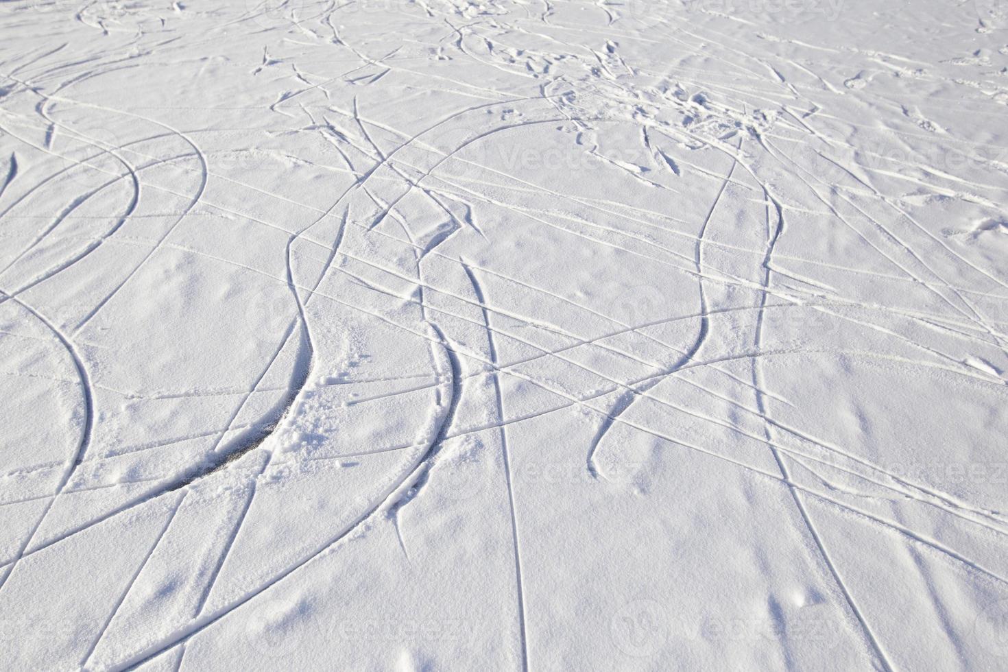 Skate tracks on ice with snowy snow. Winter background. photo