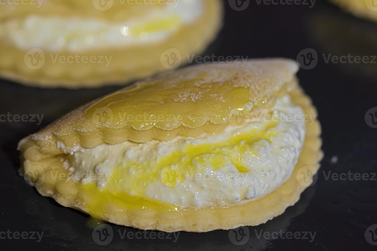 Cookies with cottage cheese on a baking sheet smeared with egg yolk. photo