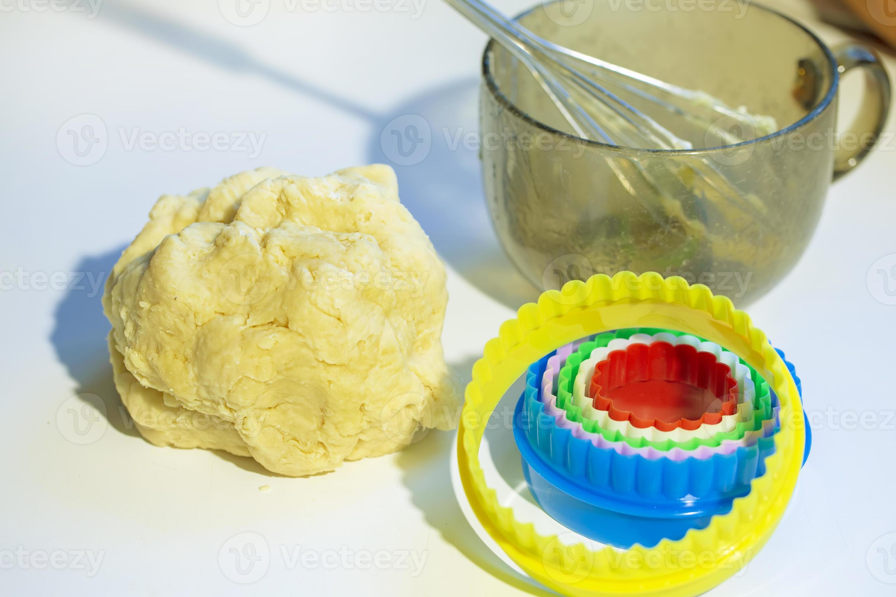 On the table is a baking dough cookie pan and a whisk. Cookies making process. 21838672 Stock