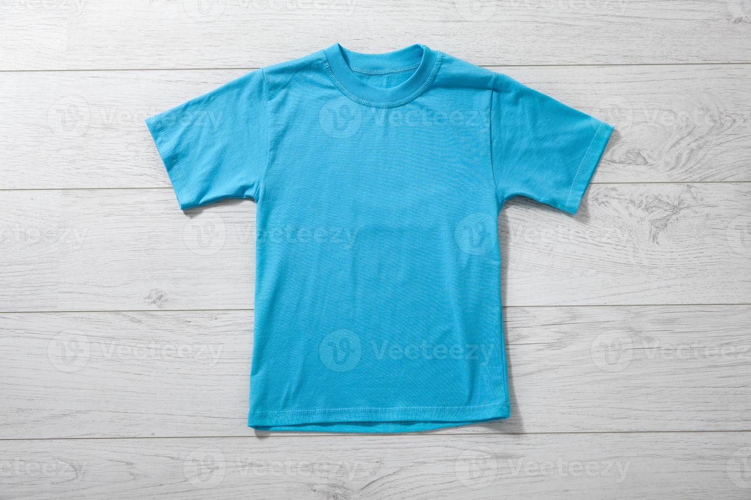 Front views on boys t-shirts on white wooden desk background. Mockup for design closeup photo