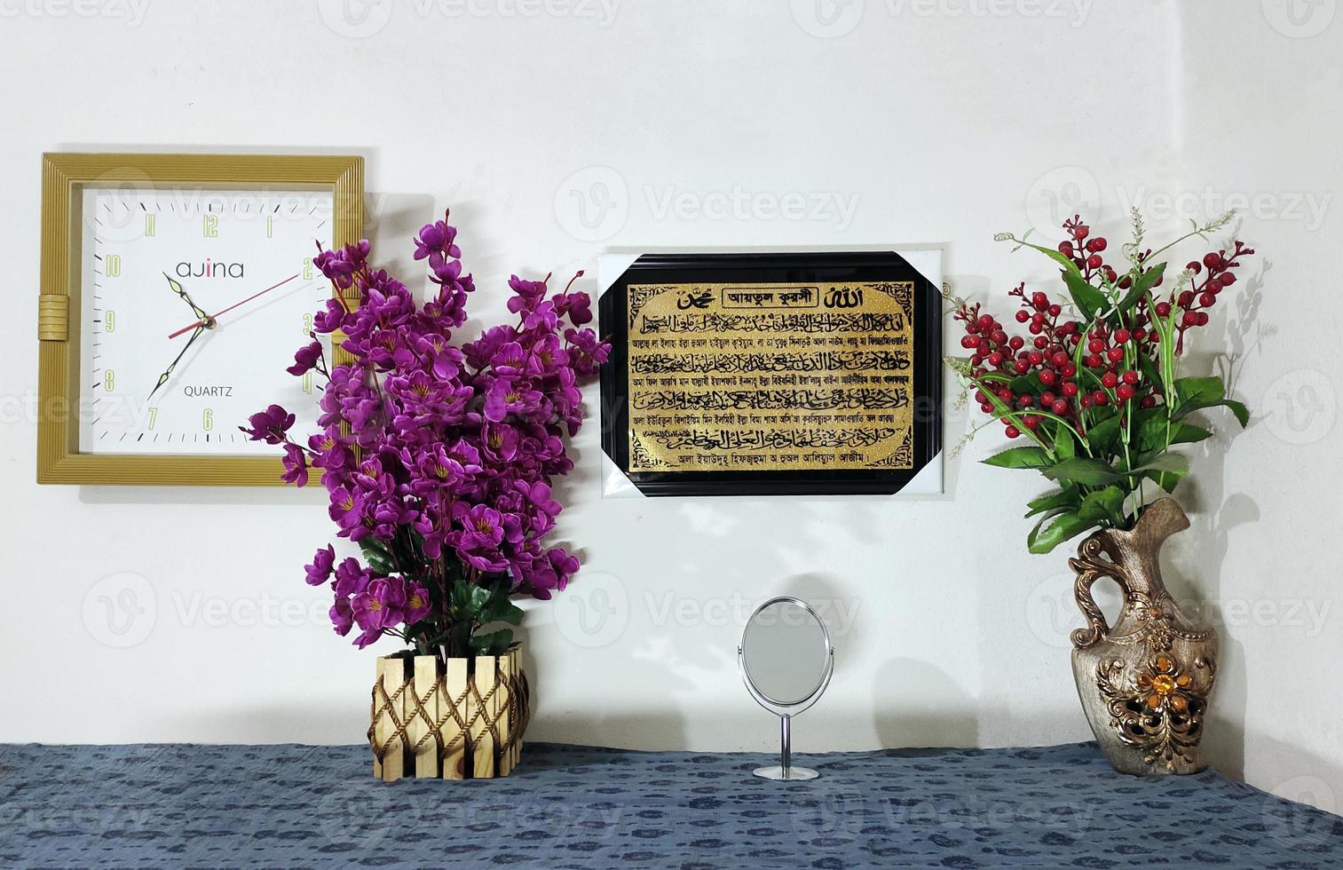 table with flowers in the interior, A sign on a wall reads the name of the place of the day, Wall clock red flowers green leaves purple photo