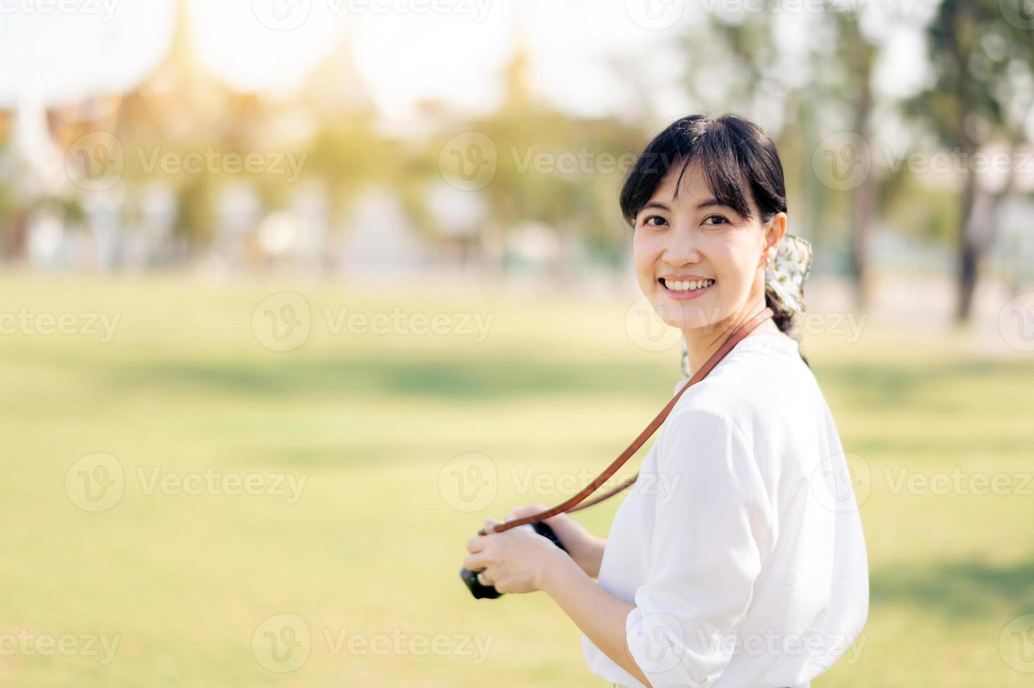 retrato de asiático mujer viajero utilizando cámara. Asia verano turismo vacaciones concepto con el grandioso palacio en un antecedentes a bangkok, Tailandia foto