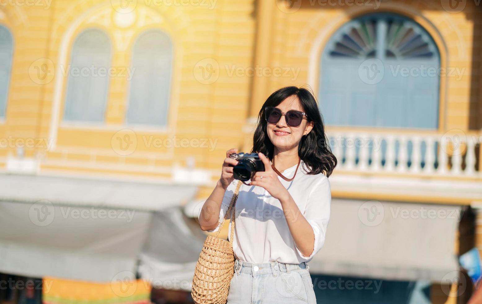retrato de asiático mujer viajero utilizando cámara. Asia verano turismo vacaciones concepto foto
